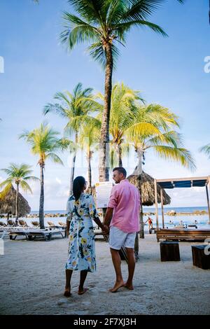 Mambo Beach auf der Karibischen Insel Curacao, schöner weißer Strand Curacao Karibik, Paar Männer und Frauen am Strand entspannen, mittleren Alters Paar asiatische Frau und europäische Männer Stockfoto