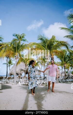 Mambo Beach auf der Karibischen Insel Curacao, schöner weißer Strand Curacao Karibik, Paar Männer und Frauen am Strand entspannen, mittleren Alters Paar asiatische Frau und europäische Männer Stockfoto