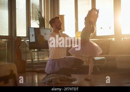 Glücklicher Vater und Tochter spielen zusammen im Wohnzimmer; Qualitätsfamilienzeitkonzept Stockfoto