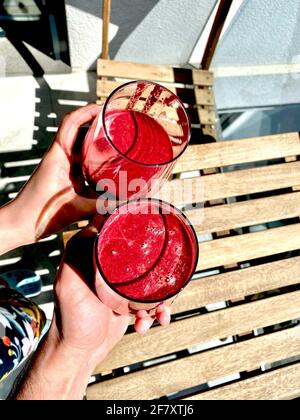 Acai Smoothie mit Rote Bete und Rüben Cheers außerhalb Sonnentag mit Freunden. Bereit zum Trinken. Stockfoto