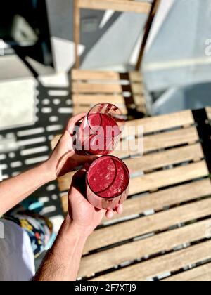 Acai Smoothie mit Rote Bete und Rüben Cheers außerhalb Sonnentag mit Freunden. Bereit zum Trinken. Stockfoto