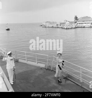 Cruiser Hr. Ms. De Ruyter (C 801) kommt in Willemstad, Curaçao, mit Königin Juliana (1909-2004, rechts) und ZKH Prins Bernhard (1911-2004, links) an Bord, um die Insel am 1955. Oktober zu besuchen. Stockfoto