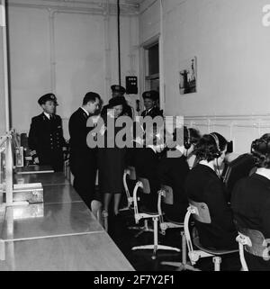 Prinzessin Beatrix bringt einen einführenden Besuch in verschiedenen Teilen der Royal Navy mit. Auf dem Gelände der Marineschutzbehörde Amsterdam (MKAD) wird eine lokale Verbindungsschule (VBS) besucht, in der Mitglieder der Marinefrauenabteilung (Marva) Unterricht erhalten. Ein Leutnant-Ter-Sea der 2. Klasse der ältesten Kategorie (LTZ 2OC) erklärt ​​the. Stockfoto