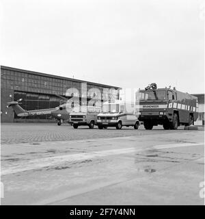 MarineLiegkamp De Kooy. Von links nach rechts: Ein Westland Lynx (SH-14C) Helikopter des Flugzeug-Quadrons 860, ein Volkswagen-Flugsicherungstransporter, ein Mercedes-Krankenwagen, ein neuer Tanker-Sprüher hoch-/Niederdruck vom Marine-Feuerwehrkorps (KMB). Stockfoto