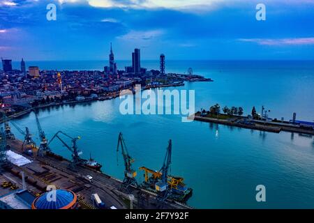 Batumi, Georgien - 7. April 2021: Batumi-Hafen, Blick auf das Stadtzentrum von einem Frachtschiff im Hafen bei hellen Sommeruntergangslichtern Stockfoto