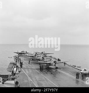 Geparkte Flugzeuge (Middle Grumman TBM-3S2 Avengers Submarine Boat Boat Archaces und rechts Hawker FGA-50 Seahawk (Jet) Jachth Aircraft) des Marine Air Shipping Service (MLD) auf dem Flugdeck des Flugzeugcamps hr.ms. Karel Doorman (R 81, ex-ehrwürdiger), 1958. Stockfoto