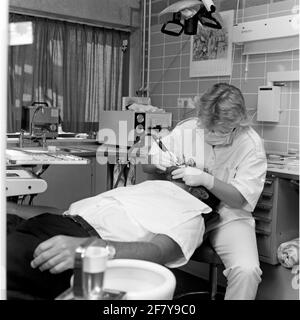 Ein Zahnarzt der Zentralkrankheit (CZB) in der Marine Barracks Willemsoord (MKWD) in Den Helder untersucht die Zähne eines Patienten (Juli 1989). Stockfoto