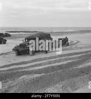 Die Traktions- und Feldfähigkeiten des International Harvester M5A1-Sattelwagens mit einer montierten 25-poligen Kanone und einem Munitionswagen auf einem verlassenen Stück Strand auf Vlieland testen. Stockfoto