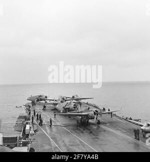 Geparkte Flugzeuge (Middle Grumman TBM-3S2 Avengers Submarine Boat Boat Archaces und rechts Hawker FGA-50 Seahawk (Jet) Jachth Aircraft) des Marine Air Shipping Service (MLD) auf dem Flugdeck des Flugzeugcamps hr.ms. Karel Doorman (R 81, ex-ehrwürdiger), 1958. Stockfoto