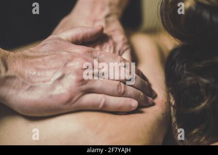 Soft-Focus-Ansicht des Mannes massieren eine Frau in einem Wellness Center geölte Hände auf einem Körper, der die Muskeln entspannt Und entlasten Spannung ganzheitliche Übung Stockfoto