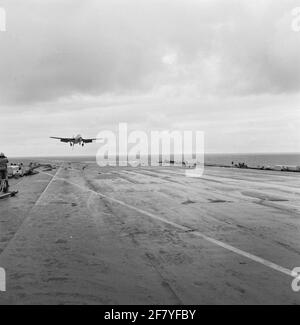 Das Hawker FGA-50 Seahawk (Jet)-Yachtflugzeug mit der Registrierung 57 (1957-1964) des Marine Aviation Service (MLD) wird am Flugzeugdeck des Flugzeuglagers HR landen Karel Doorman (R 81, ex-ehrwürdiger) im Jahr 1958. Der Bremshaken am Heck des Jägers und die Bremsseile am Flugdeck sind gut zu sehen. Stockfoto