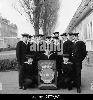 Klassenfoto auf dem Gelände der Marine Barracks Amsterdam (MKAD) bei den technischen Kursen der Royal Netherlands Marine (Tokm). Eine Klasse mit Elektroingenieuren der 2. Klasse (Elmnt 2) posiert mit dem Wappen der Tokm. Stockfoto