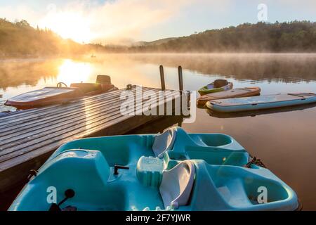 Boote und Bretter, die im Sommer auf einem Deck schwimmen Ein Sonnenaufgang Stockfoto