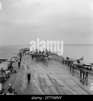 Geparkte Flugzeuge (Middle Grumman TBM-3S2 Avengers Submarine Boat Boat Archaces und rechts Hawker FGA-50 Seahawk (Jet) Jachth Aircraft) des Marine Air Shipping Service (MLD) auf dem Flugdeck des Flugzeugcamps hr.ms. Karel Doorman (R 81, ex-ehrwürdiger), 1958. Stockfoto