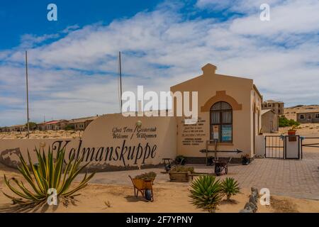 KOLMANSKOP, NAMIBIA - JANUAR 04.2021: Eingang der Geisterstadt Kolmanskop in Namibia mit dem Schild Kolmanskuppe in deutscher Sprache mit blauem Himmel Stockfoto