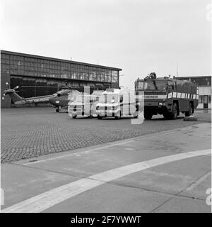 MarineLiegkamp De Kooy. Von links nach rechts: Ein Westland Lynx (SH-14C) Helikopter des Flugzeug-Quadrons 860, ein Volkswagen-Flugsicherungstransporter, ein Mercedes-Krankenwagen, ein neuer Tanker-Sprüher hoch-/Niederdruck vom Marine-Feuerwehrkorps (KMB). Stockfoto