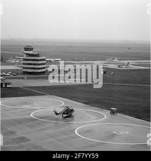 MarineLiegkamp De Kooy. Auf der linken Seite der Verkehrsturm. Im Vordergrund ein Westland Lynx SH-14B Hubschrauber, Registernummer 270. In der Mitte rechts, 2 Sikorsky S-61N Hubschrauber von KLM Noordzee Hubschraubern. Stockfoto