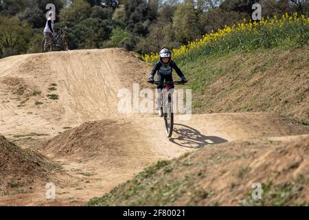 Junge übt Sprünge auf seinem Mountainbike in einem Bikepark in Forallac, Katalonien, Spanien Stockfoto