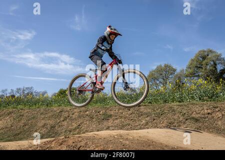 Junge übt Sprünge auf seinem Mountainbike in einem Bikepark in Forallac, Katalonien, Spanien Stockfoto