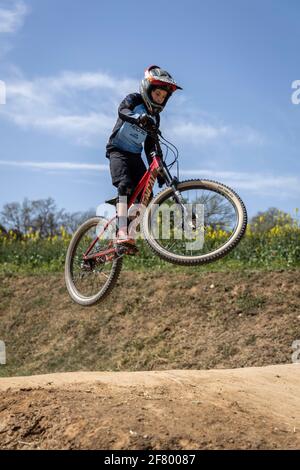 Junge übt Sprünge auf seinem Mountainbike in einem Bikepark in Forallac, Katalonien, Spanien Stockfoto