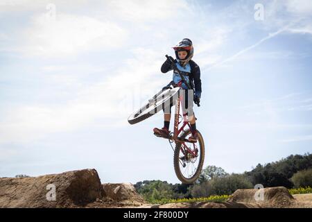 Junge übt Sprünge auf seinem Mountainbike in einem Bikepark in Forallac, Katalonien, Spanien Stockfoto