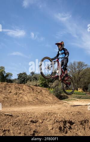 Junge übt Sprünge auf seinem Mountainbike in einem Bikepark in Forallac, Katalonien, Spanien Stockfoto