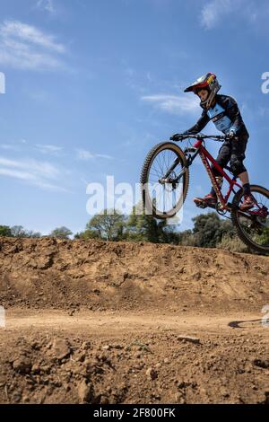 Junge übt Sprünge auf seinem Mountainbike in einem Bikepark in Forallac, Katalonien, Spanien Stockfoto