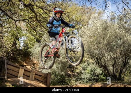 Junge übt Sprünge auf seinem Mountainbike in einem Bikepark in Forallac, Katalonien, Spanien Stockfoto