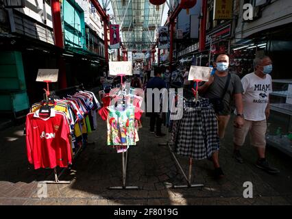 Käufer, die Gesichtsmasken tragen, um die Verbreitung des Covid-19 zu verhüten, laufen an einem Straßenladen im Gebiet von China Town vorbei. Stockfoto