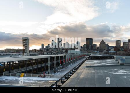 Blick auf eine Stadt von der Spitze eines Parkplatzes Grundstück mit hohen Gebäuden in der Ferne und Wolken Der Himmel Stockfoto