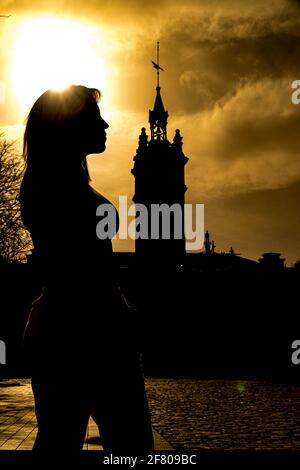 Aufnahme der Silhouette einer Spanierin im Profil Mit einem Turm hinter ihr während des Sonnenuntergangs Stockfoto