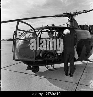 Der Staatssekretär für Verteidigung (StasDEF) J. van Houwelingen befindet sich in einem mutmaßlichen Sud-Aviation Alouette III Hubschrauber der Royal Netherlands Air Force. Im Hintergrund ist ein Westland-Lynx Hubschrauber der Royal Navy. Stockfoto