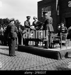 Prinzessin Irene besucht das Wardregiment Fuselers 'Prinzessin Irene' in der Frederik Hendrikkazerne in Vught. Zwei Soldaten zeigen der Prinzessin ein Dokument, das den Soldaten gerade in einer Hülle übergeben hat. Stockfoto