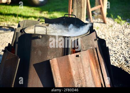 Der traditionelle Fisch kocht mit frischem Lake Michigan Weißfisch, roten Kartoffeln, Zwiebeln und dem von Boilmaster, Door County, Wisconsin, USA, mit Kerosin übergossenen Feuer Stockfoto