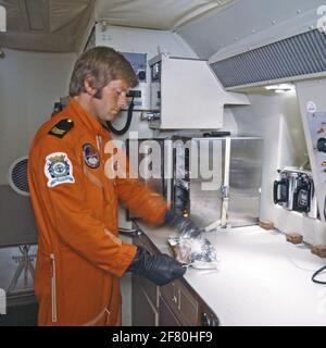 Ein Sergeant des Flugzeuges Quadron 320 (VSQ 320) erwärmt eine Mahlzeit in der Speisekammer an Bord einer Lockheed P-3C Orion des Marine Aviation Service (MLD). Stockfoto