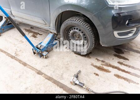 Moskau. Russland. Frühjahr 2020. Fahrzeug auf dem Wagenheber, bevor das Rad ersetzt wird. Vorbereitung auf den Austausch von Winterrädern durch Sommerräder. Stockfoto