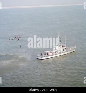 Luftaufnahme des Trainingsschiffes T.B.V. Das Royal Institute for the Marine (Kim) HR.Ms. Bulgia (A 880), der im April 1991 einen persönlichen Transfer mit einem Hebezeug vom Hubschrauber der Westland H-14 Navy Lynx mit Registrierung 283 (1981-2012) durchführt. Stockfoto