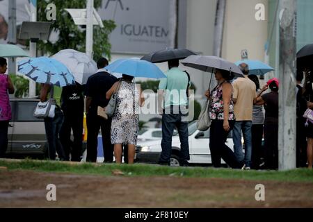 salvador, bahia / brasilien - 23. april 2013: Menschen werden bei Fußgängerübergängen in der Stadt Salvador, Bahia, mit Regenführungen beobachtet. Stockfoto
