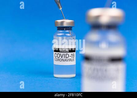 Vakzinfläschchen aus der Nähe, Vorbereitung auf die Immunisierung gegen COVID-19, blaues Hintergrundfoto Stockfoto