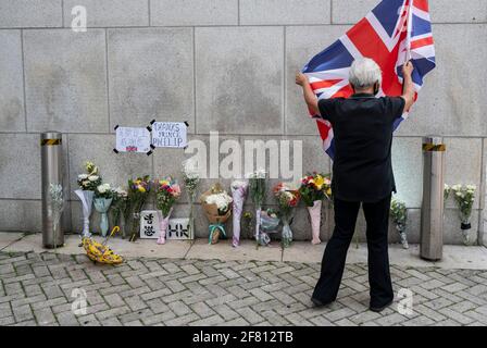 Hongkong, China. April 2021. Eine Frau hält die britische Flagge vor der Botschaft Britisches Generalkonsulat Hongkong nach der Ankündigung des Todes des britischen Prinzen Philip in Hongkong. Prinz Philip, Ehemann von Königin Elizabeth II., starb im Alter von 99 Jahren. (Foto von Miguel Candela/SOPA Images/Sipa USA) Quelle: SIPA USA/Alamy Live News Stockfoto