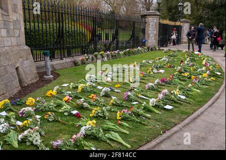 Windsor, Großbritannien. April 2021. Hunderte von Menschen waren heute in Windsor, um ihrer Majestät der Königin nach dem traurigen gestrigen Tod ihres geliebten Mannes, S.H. Prinz Philip, des Herzogs von Edinburgh, Blumen zu zollen. Auf dem langen Weg wurden Blumen vor den Toren von Windsor Castle auf das Gras gelegt. Viele Fernsehsender wurden in Windsor heute live übertragen. Es wurde bekannt gegeben, dass die Beerdigung von S.H. Prinz Philip eine private Veranstaltung sein wird, die am Samstag, dem 17. April 2021, in der St. George's Chapel stattfinden wird. Quelle: Maureen McLean/Alamy Stockfoto