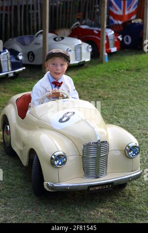 Kleiner Junge mit den Tretautos Austin J40 beim Goodwood Revival Meeting in Chichester, West Sussex, Großbritannien. Stockfoto