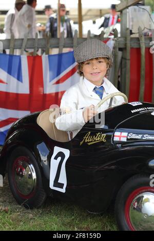 Kleiner Junge mit den Tretautos Austin J40 beim Goodwood Revival Meeting in Chichester, West Sussex, Großbritannien. Stockfoto