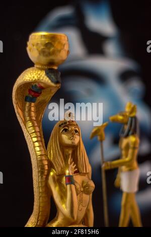 Stillleben mit ägyptischen Figuren von anubis und kleopatra mit Schlange in Gold. Stockfoto