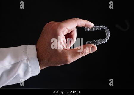 Doktor Hand hält einen klaren Zahnausrichter Stockfoto