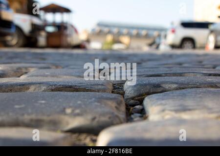 Nahaufnahme uralter Pflastersteine. Blick von der Straßenebene. Synthese von Alt und Neu Stockfoto