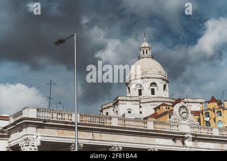 Blick auf die Kirche Santa Engracia oder einen anderen Namen National Pantheon, mit einer schönen teilweise stürmischen Wolkenlandschaft im Hintergrund und einem Gebäude Stockfoto