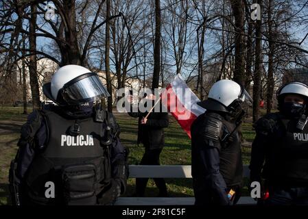 10. April 2021, Warschau, Warschau, Polen: Ein Demonstranten hält während eines regierungsfeindlichen Protestes am 10. April in Warschau, Polen, eine polnische Flagge. Ein paar Dutzend Menschen versammelten sich auf dem Pilsudskiego-Platz in Warschau, um gegen die Regierung und die neuesten Beschränkungen zu protestieren, die eingeführt wurden, um die Ausbreitung von SARS-CoV-2 einzudämmen. Die Demonstration wurde am selben Tag des 11. Jahrestages des Flugzeugabsturzes in Smolensk organisiert, an dem der Vorsitzende der Regierungspartei Recht und Gerechtigkeit (PiS), Jaroslaw Kaczynski, trotz der Einschränkungen von einem Dutzend anderer Regierungsvertreter begleitet, teilnimmt. (Bild: © Stockfoto