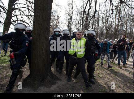 10. April 2021, Warschau, Warschau, Polen: Am 10. April wird in Warschau, Polen, ein regierungsfeindlicher Demonstranten von der Polizei festgenommen. Ein paar Dutzend Menschen versammelten sich auf dem Pilsudskiego-Platz in Warschau, um gegen die Regierung und die neuesten Beschränkungen zu protestieren, die eingeführt wurden, um die Ausbreitung von SARS-CoV-2 einzudämmen. Die Demonstration wurde am selben Tag des 11. Jahrestages des Flugzeugabsturzes in Smolensk organisiert, an dem der Vorsitzende der Regierungspartei Recht und Gerechtigkeit (PiS), Jaroslaw Kaczynski, trotz der Einschränkungen von einem Dutzend anderer Regierungsvertreter begleitet, teilnimmt. (Bild: © Aleksande Stockfoto