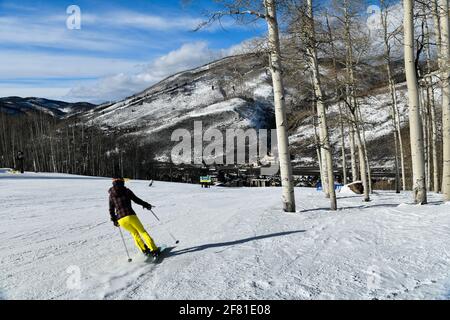 Rückansicht einer Frau, die in Vail Colorado, USA, die Piste hinunter fährt Stockfoto